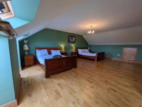 a bedroom with two beds and a green wall at Cloonacauneen House in Balnacart