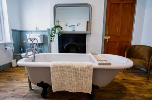 a white bath tub in a room with a mirror at Beach View - A Truly Stunning House Opposite The Sea! Sleeps 10! Families, Friends, Contractors and Pets are all Welcome! in Sandgate