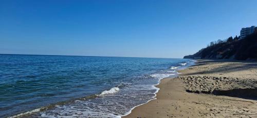 a beach with the ocean on a sunny day at Студио Бяла in Byala