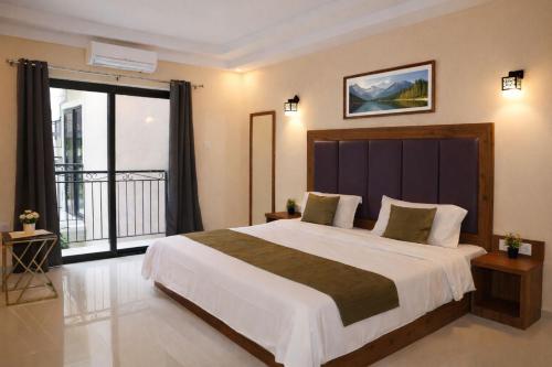 a bedroom with a large bed and a large window at Hotel Centro in Calangute