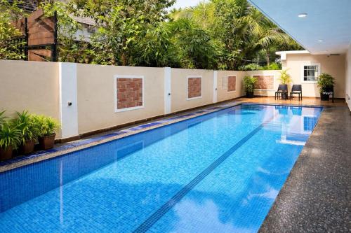 a large swimming pool with blue water in a building at Hotel Centro in Calangute