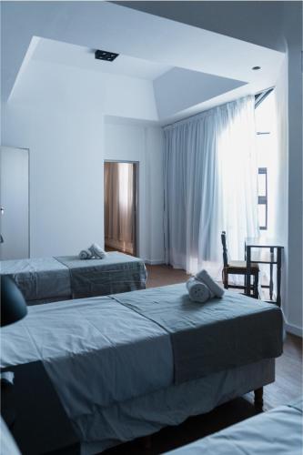 ein Hotelzimmer mit zwei Betten und einem Fenster in der Unterkunft Form Hotel in Zárate