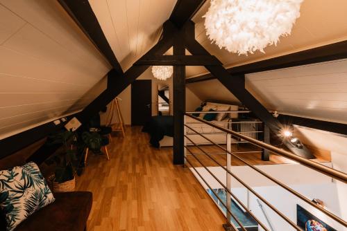 ein Dachzimmer mit Holzbalken, einer Couch und Lampen in der Unterkunft Le Clos E in Theux