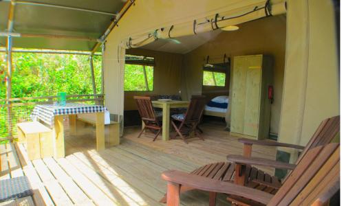 a room with a porch with chairs and a table at Lodge Holidays - Casa Tartufo in Radicosa