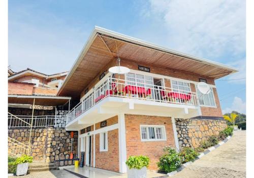 a house with a balcony with red chairs on it at Kivu Hotel Resort in Kibuye