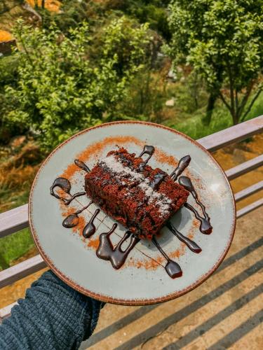 a plate with a piece of food on a table at Private Mudhouse Duplex Cottage by Kahani in Jibhi