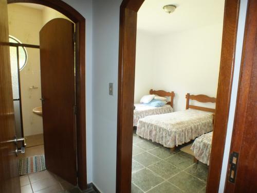 a room with a bedroom with a bed and a mirror at Casa da Vó Lucia in Serra Negra