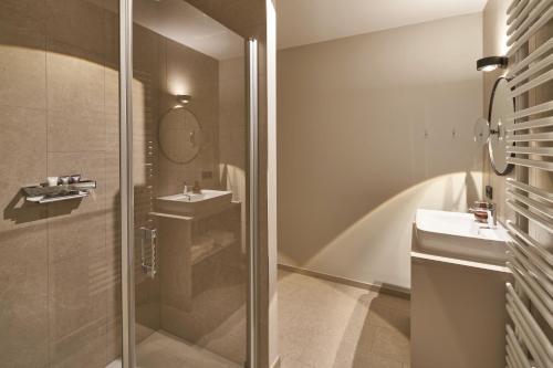 a bathroom with a shower and a sink and a mirror at Michels Dependance des Hotel Misan in Norderney