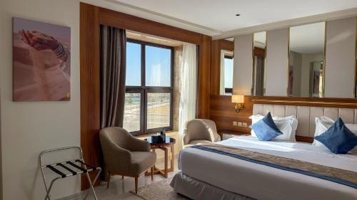 ein Hotelzimmer mit einem Bett und einem Fenster in der Unterkunft Corp Yanbu Hotel - B1 in Yanbu