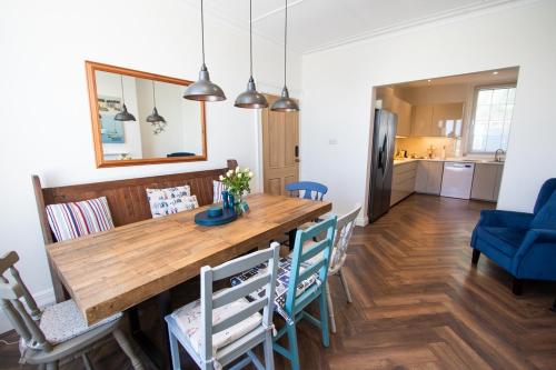 a kitchen and dining room with a wooden table and chairs at Beach View - A Truly Stunning House Opposite The Sea! Sleeps 10! Families, Friends, Contractors and Pets are all Welcome! in Sandgate