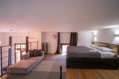 a bedroom with a bed and a couch at My exclusive cavour loft da sogno a cagliari in Cagliari