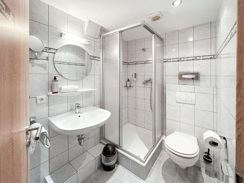a bathroom with a shower and a toilet and a sink at DORMERO Hotel Crailsheim in Crailsheim