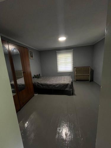 an empty room with a bed and a window at Дідова Хата in Sheshory