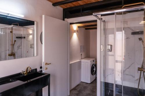 a bathroom with a shower and a sink and a washing machine at My exclusive cavour loft da sogno a cagliari in Cagliari