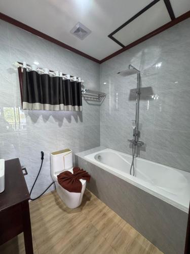 a bathroom with a tub and a toilet and a sink at Paradise resort, Don Det river view in Don Det