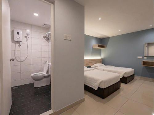 a hotel room with two beds and a toilet at De UPTOWN Hotel @ P.J. 222 in Petaling Jaya