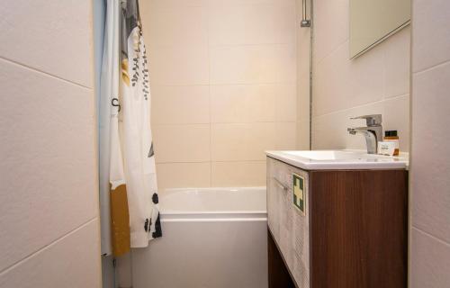 a bathroom with a sink and a bath tub at Casa da Flor in Lagos in Lagos