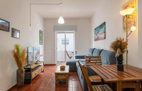 a living room with a blue couch and a table at Casa da Flor in Lagos in Lagos