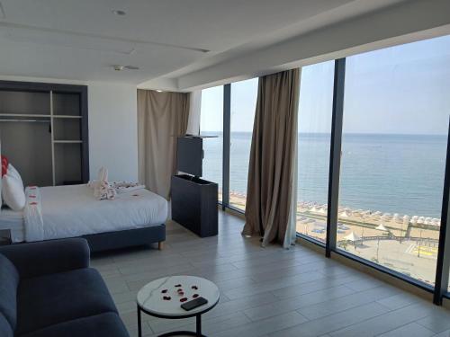 a hotel room with a bed and a view of the ocean at BOUMERDES PLAZA Hôtel & Spa in Boumerdes