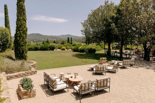 a patio with a table and chairs and a lawn at Mas de Torrent Hotel & Spa, Relais & Châteaux in Torrent