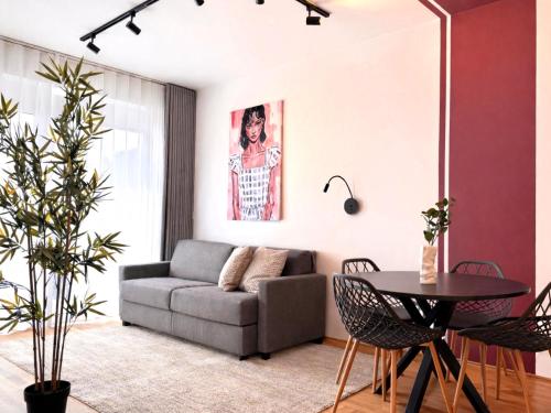 a living room with a couch and a table at M2Suites by BestChoice - Messe - Parking - Self-Check-in in Graz