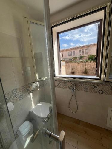 a bathroom with a window and a toilet and a sink at Antiche mura in Palermo