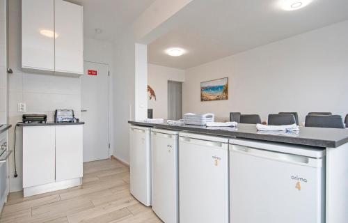 a kitchen with white cabinets and a counter with chairs at The Chairs Place GuestHouse in Lagos