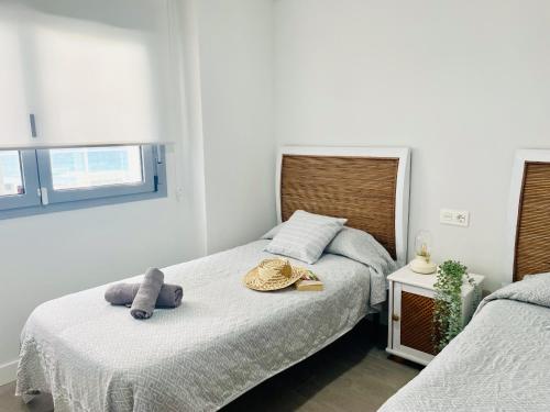 a bedroom with two beds and a stuffed animal on the bed at Ático frontal al mar en Duna Beach con vistas in Torrox Costa