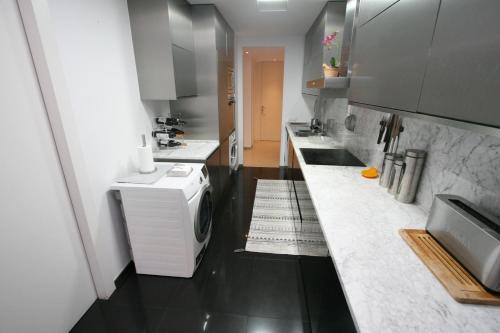 a small kitchen with a washer and dryer in it at Foz Palace - Praia da Rocha in Portimão