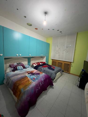 two beds in a room with blue cabinets at private room in Seveso