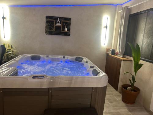 a jacuzzi tub with blue lights in a room at Gîte en Sarthe avec sauna et jacuzzi in Saint-Georges-du-Rosay