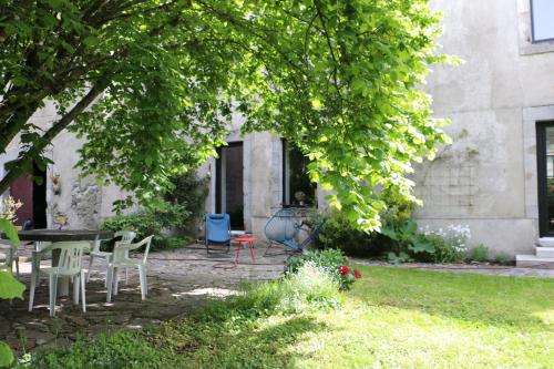 une terrasse avec des chaises et une table dans un jardin dans l'établissement Le Chai, à La Celle-sous-Gouzon