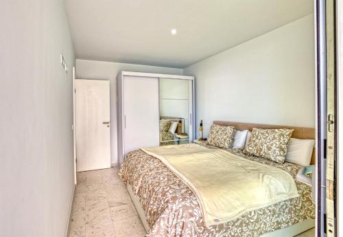a bedroom with a large bed and a mirror at MSV Beach in Puerto Naos