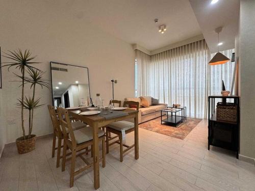 a dining room with a table and a living room at Luxury 1-bedroom fully furnished Lifeline apartment in Abu Dhabi