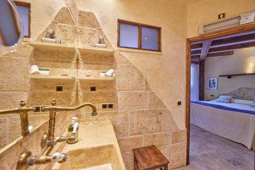 a bathroom with a sink in a room with a bed at Petit Hotel Ses Rotges - Only Adults in Cala Ratjada