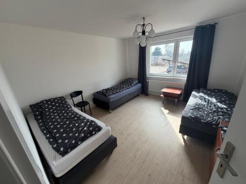 a room with two beds and a window at Kwatera pracownicza Leszno in Leszno