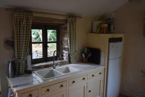 a kitchen with a sink and a window at Gîte Léon, Beynat, Corrèze in Beynat