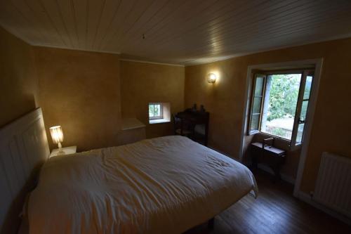 a bedroom with a white bed and a window at Gîte Léon, Beynat, Corrèze in Beynat