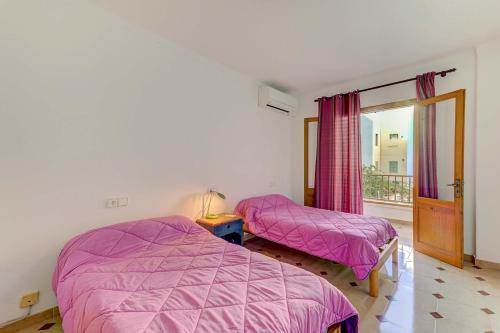 a bedroom with two beds and a window at Emma Beachfront Apartment by Sealand Villas in Port de Pollensa