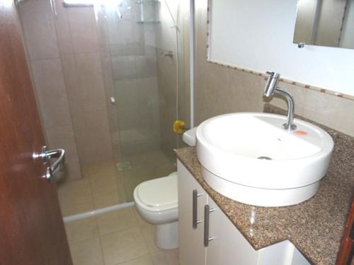 a bathroom with a sink and a toilet and a shower at Novo Lar 1 Bombinhas (Eliseos) in Bombinhas