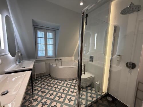 a bathroom with a tub and a sink and a shower at Apartament Kirkor przy Dworku Bielin in Bielin
