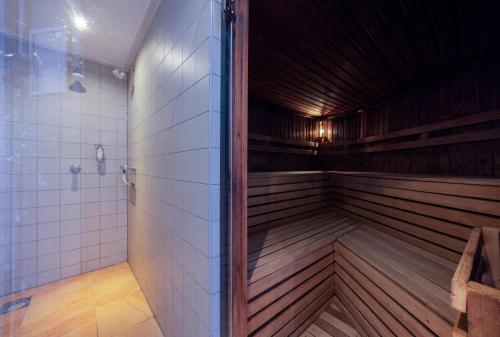 a sauna with wooden floors and white tiles at Fletcher Resort-Hotel Zutphen in Zutphen
