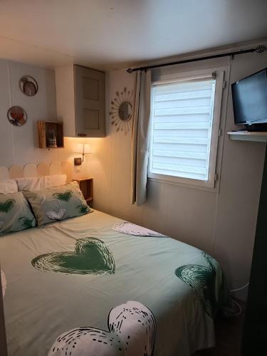 a bedroom with a bed and a window and a window at Mobile home in Quimper