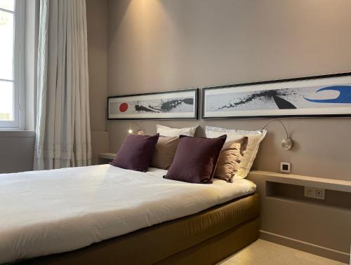 a bedroom with a large bed with two pillows at Chambre Gounod in Nice