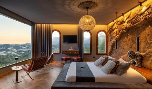 a bedroom with a large bed in a room with windows at Finca el Tossal - Adults Only in Bolulla