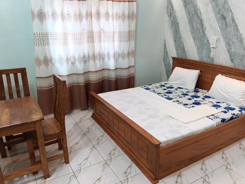 a bedroom with a bed and a desk and a chair at Guest House ETE-D Plus in Bohicon