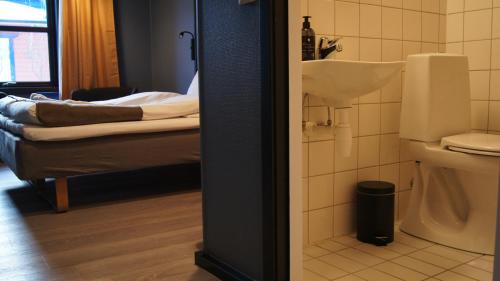 a bathroom with a sink and a bed in a room at Marina Hotel Sortland in Sortland