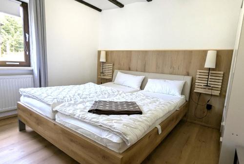 a bedroom with a large bed with a wooden headboard at Ferienwohnung am Badesee in Arrach