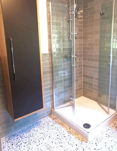 a shower with a glass door in a bathroom at Ferienwohnung am Badesee in Arrach