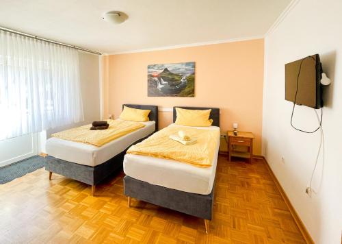 two beds in a room with a tv at Modern Apartment Wissenbach 1 in Eschenburg
